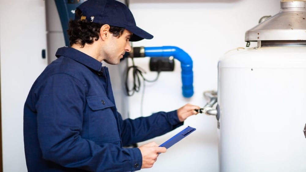 Plumber checking a valve on a water heater's supply piping