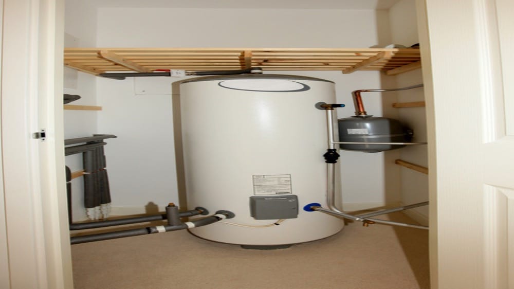 Tank water heater installed in a small utility closet