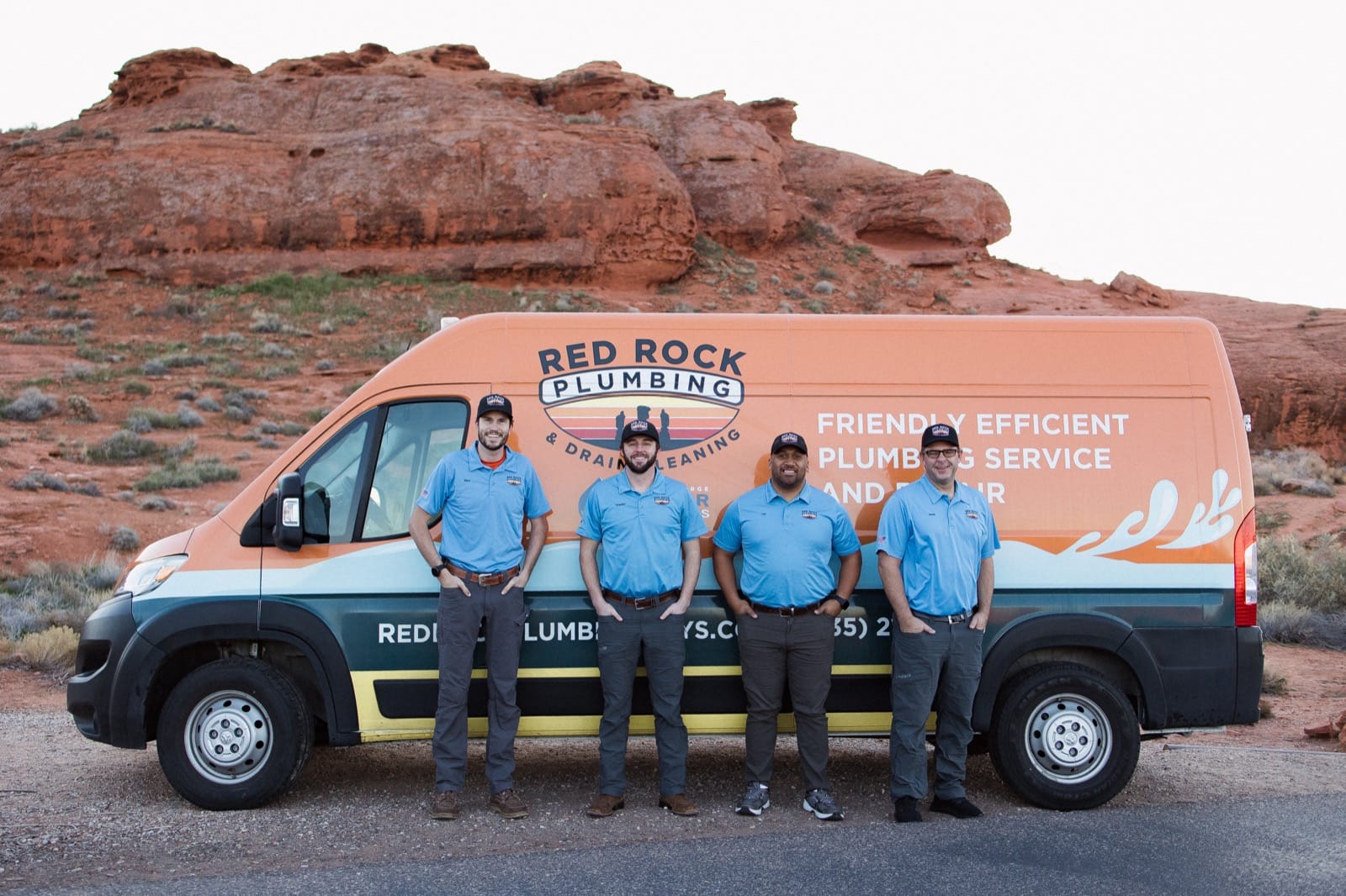 Red Rock Plumbing team in front of branded van with red rock formations behind