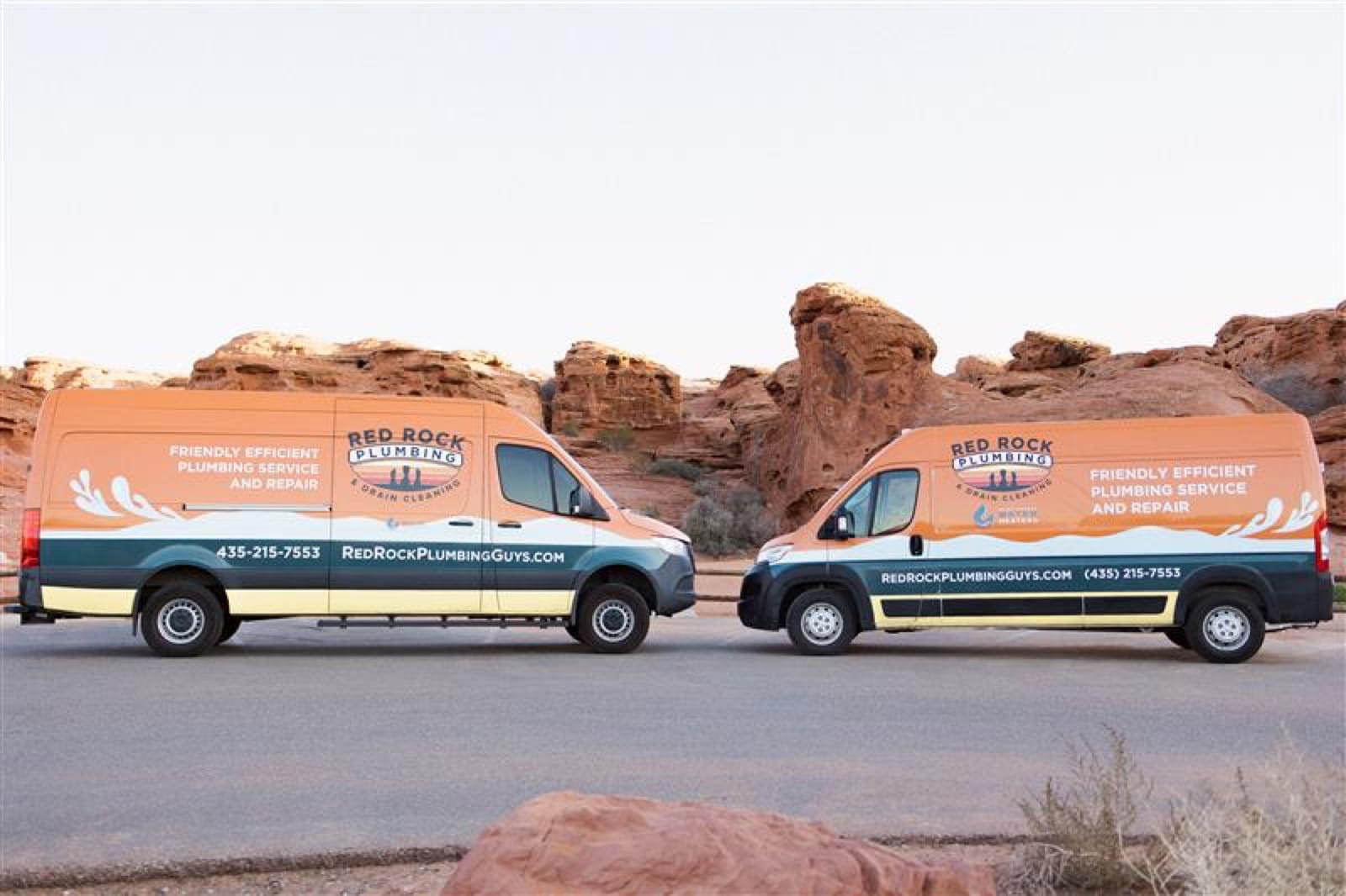 Red Rock Plumbing branded service vans parked in front of red rock formations