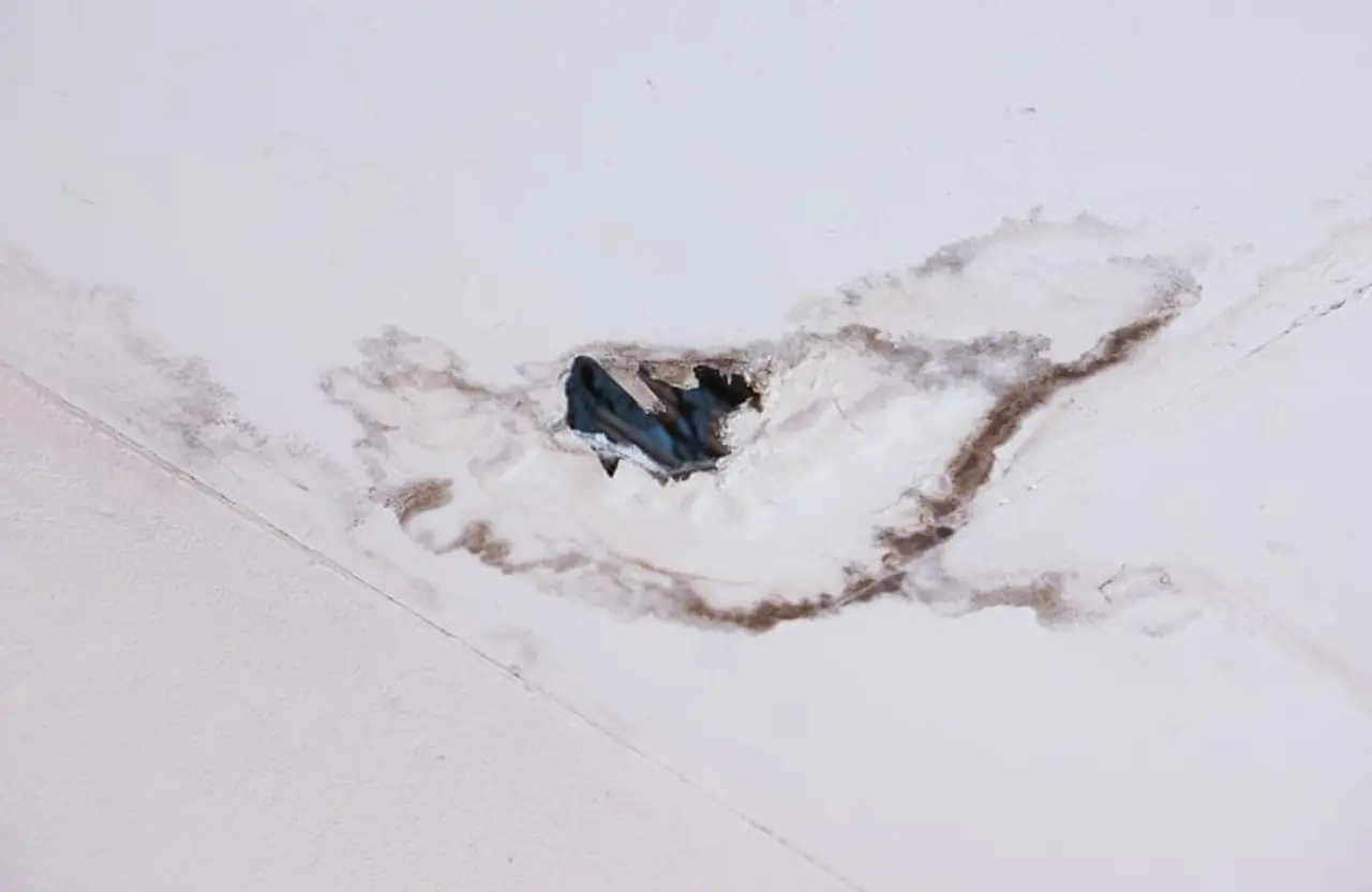 Ceiling with visible water staining and damaged plaster